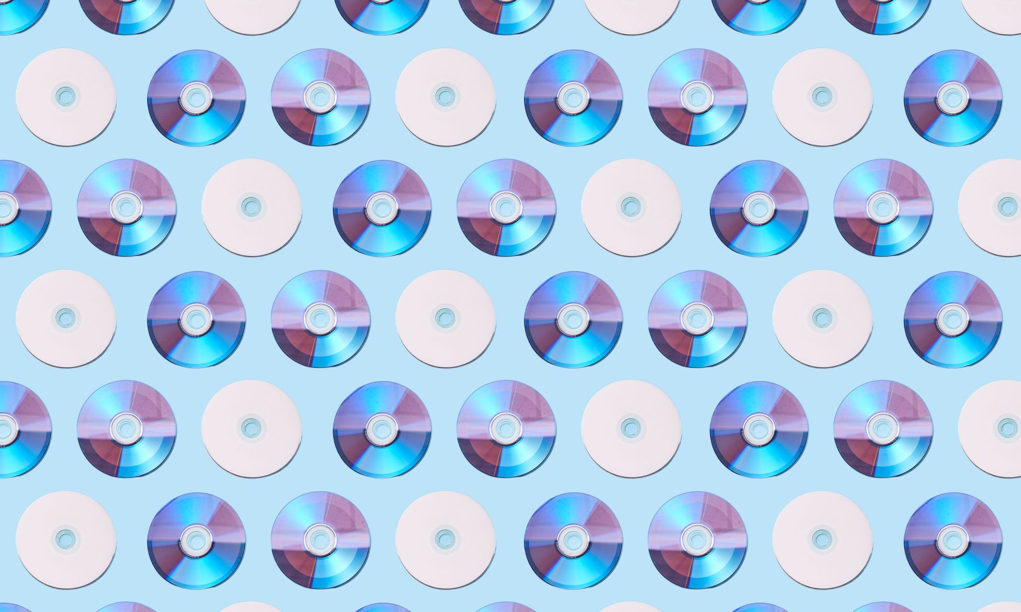 Colorful CDs arranged in a geometric pattern on a light blue background.