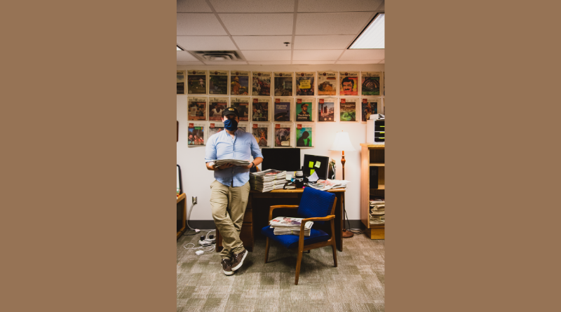 Man surrounded by newspapers